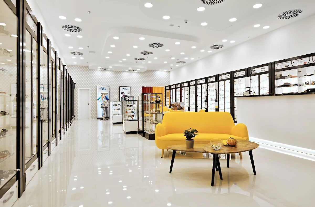 Interiér optiky, velký žlutý gauč uprostřed