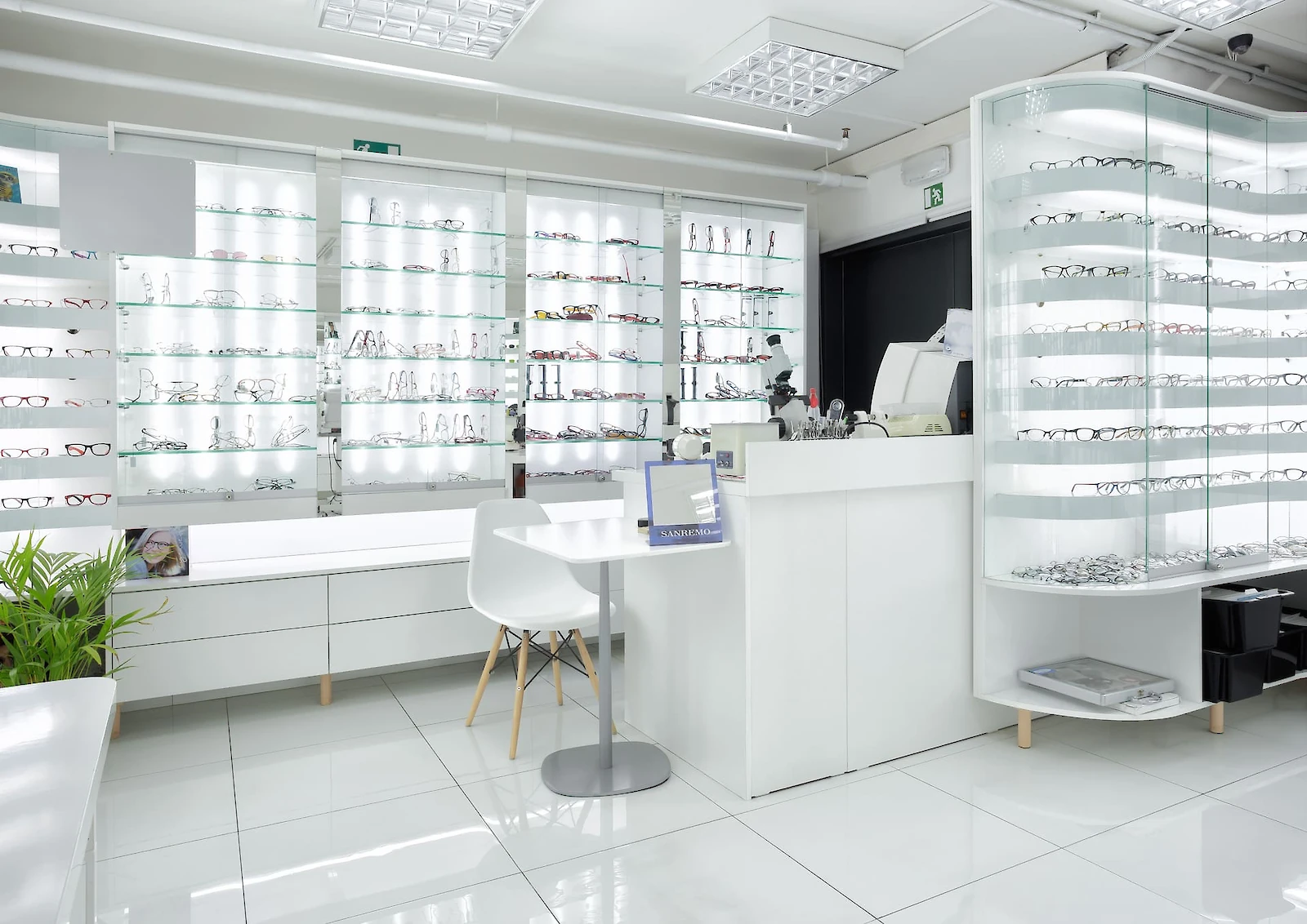 Oblá vitrína s brýlemi, pokladna, vitríny