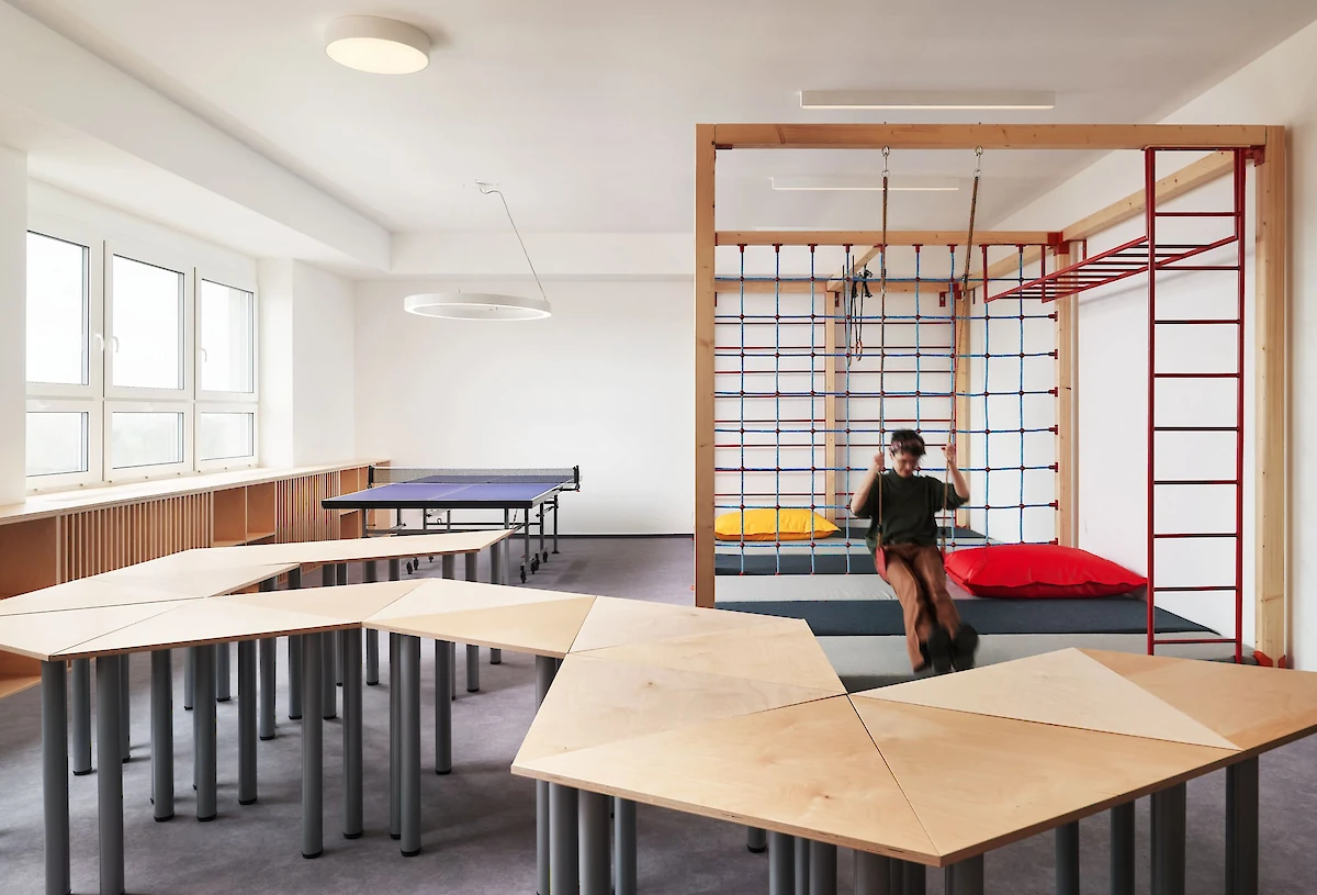 Trojúhelníkové stoly poskládané k sobě a lanové prolézačky