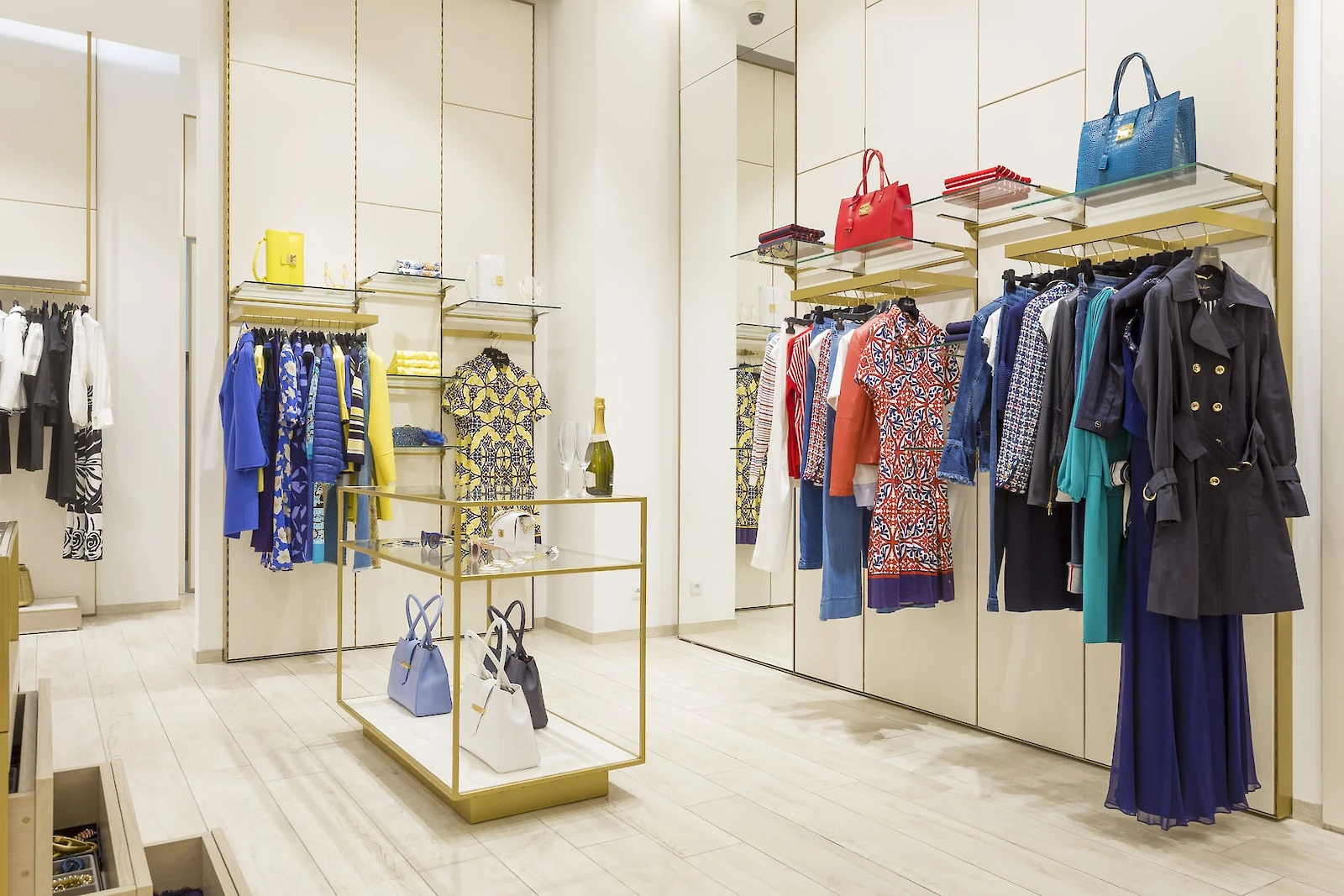 Věšákové systémy, police a skleněný stolek s oblečením a doplňky