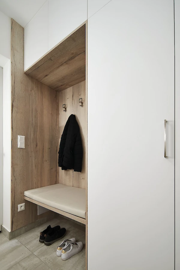 Interiér předsíně - věšáčky, skříň a lavice na sezení