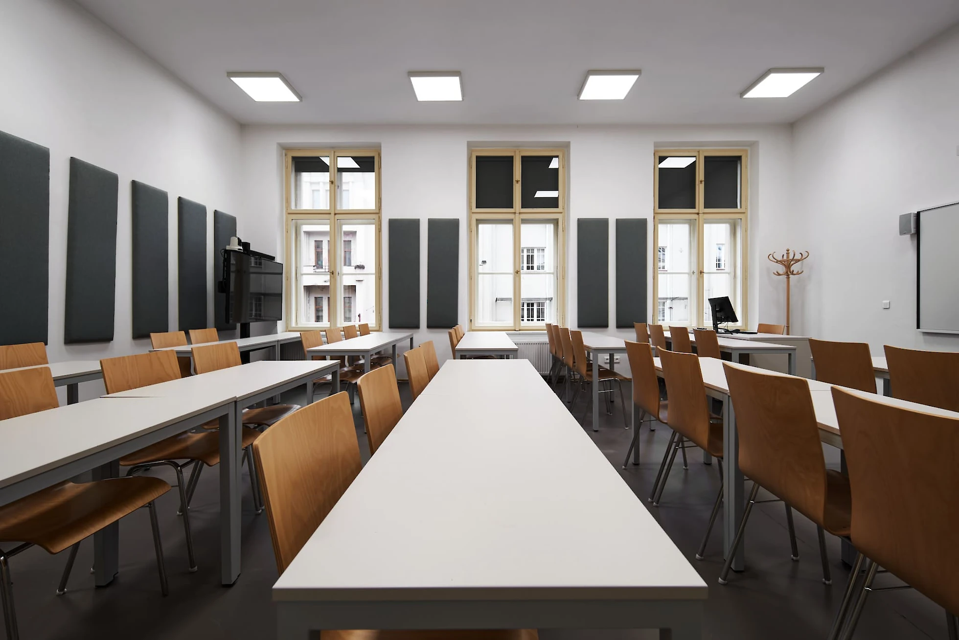Učebna s dlouhými lavicemi a židlemi