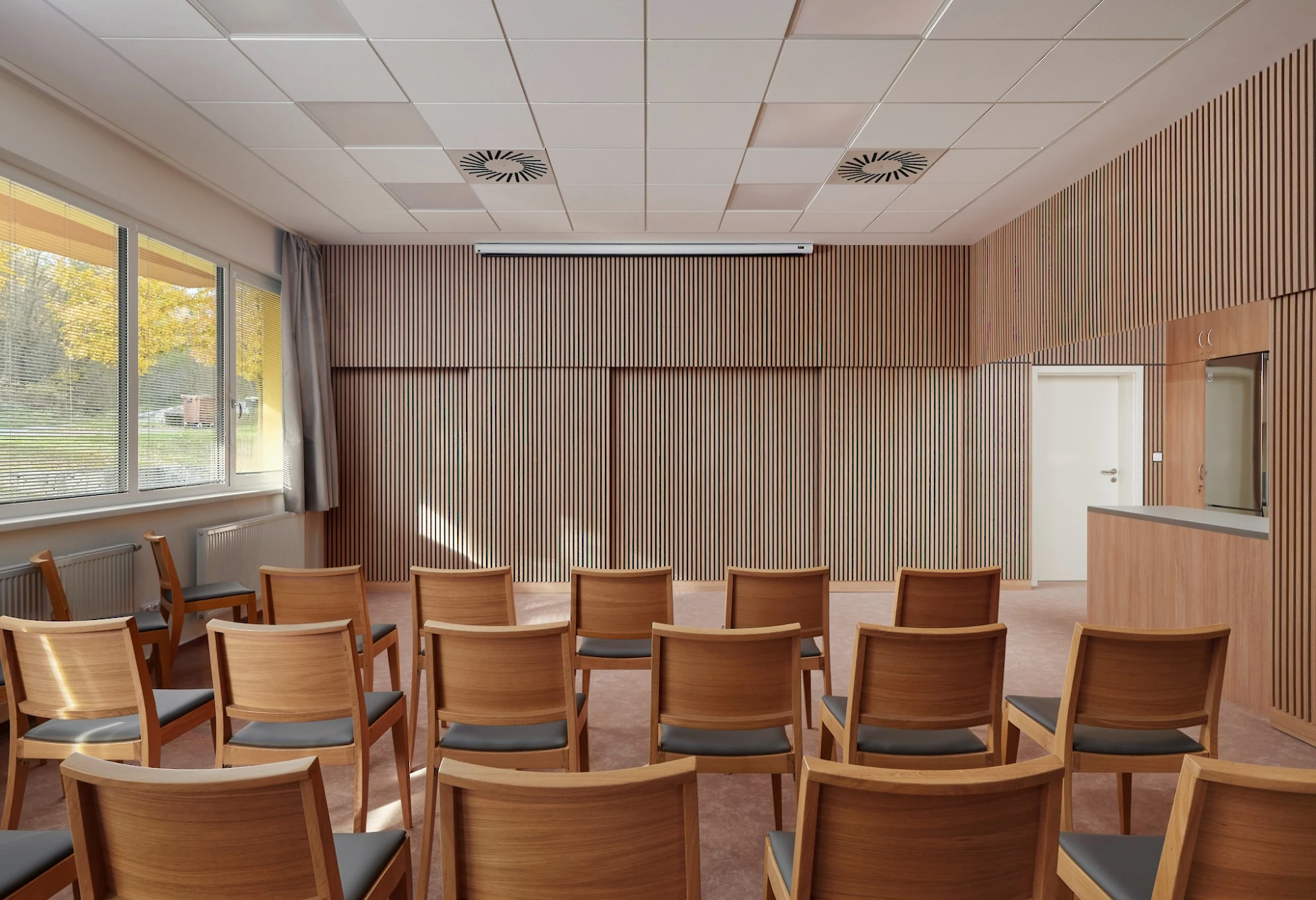 Komunitní sál s obložením a židlemi